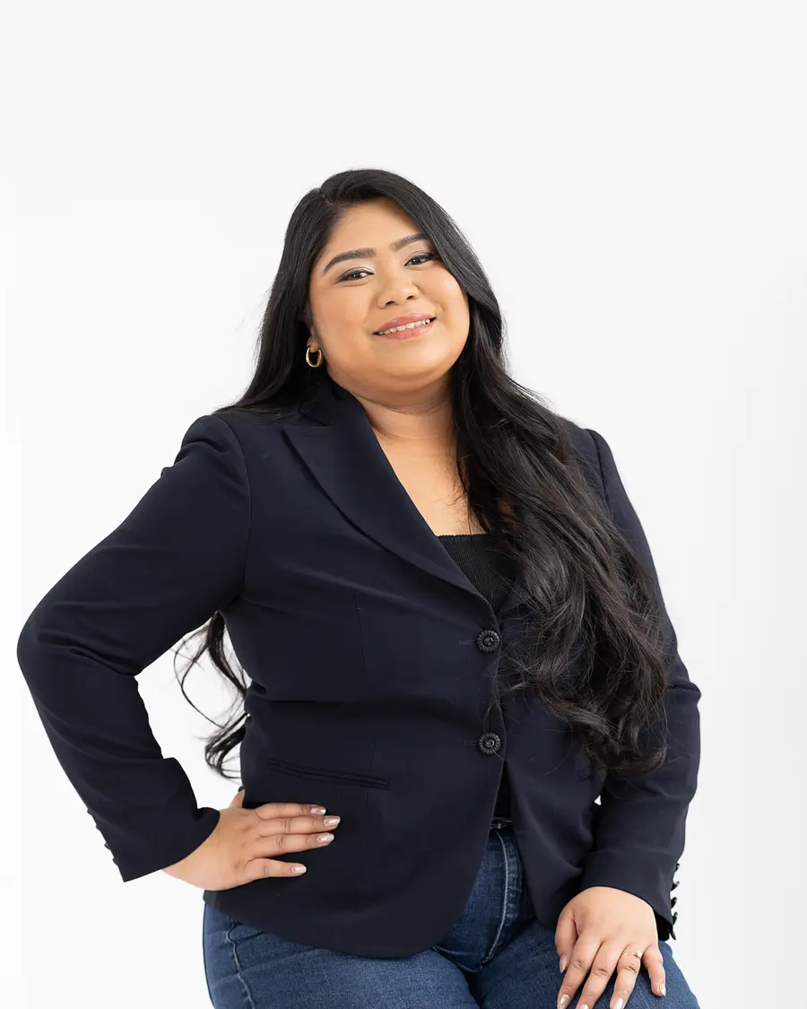 Chelsea Javier standing with one hand on her hip, wearing a navy blazer